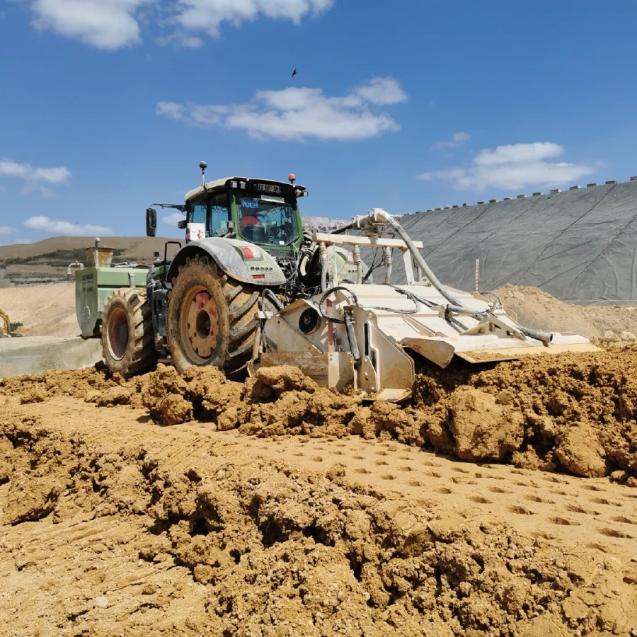 Tracteur qui pousse de la terre dans le cadre de stockage de déchets